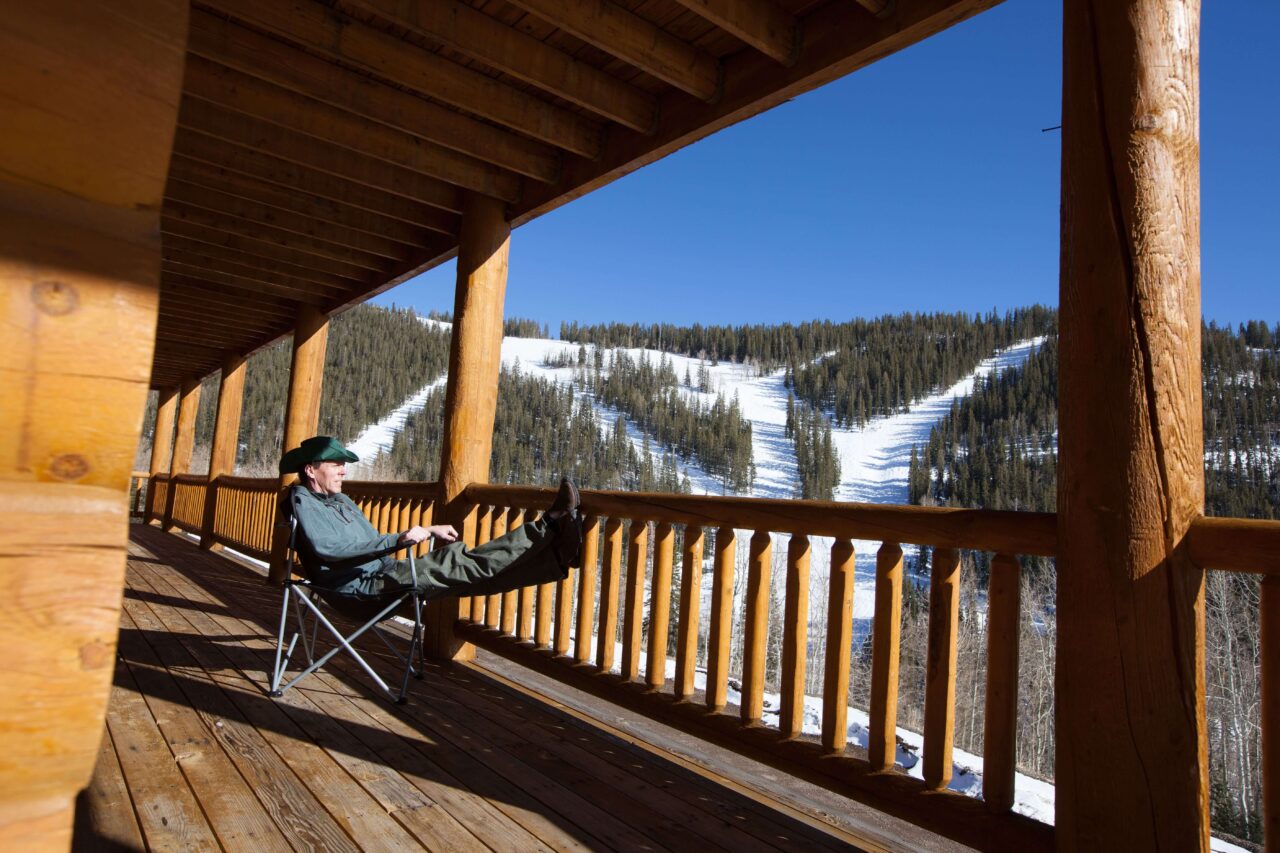 man sitting on the porch of a cabin